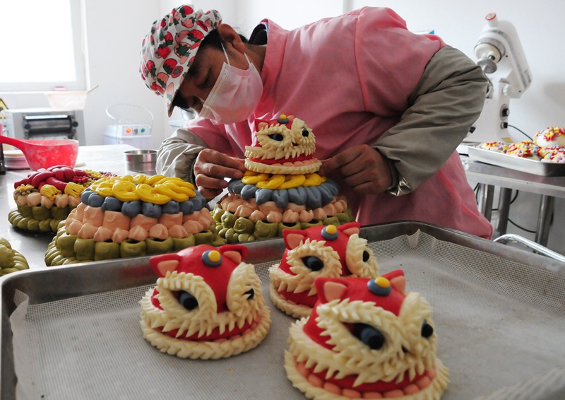 面點師在製作“醒獅發財”五彩花糕。張振祥攝